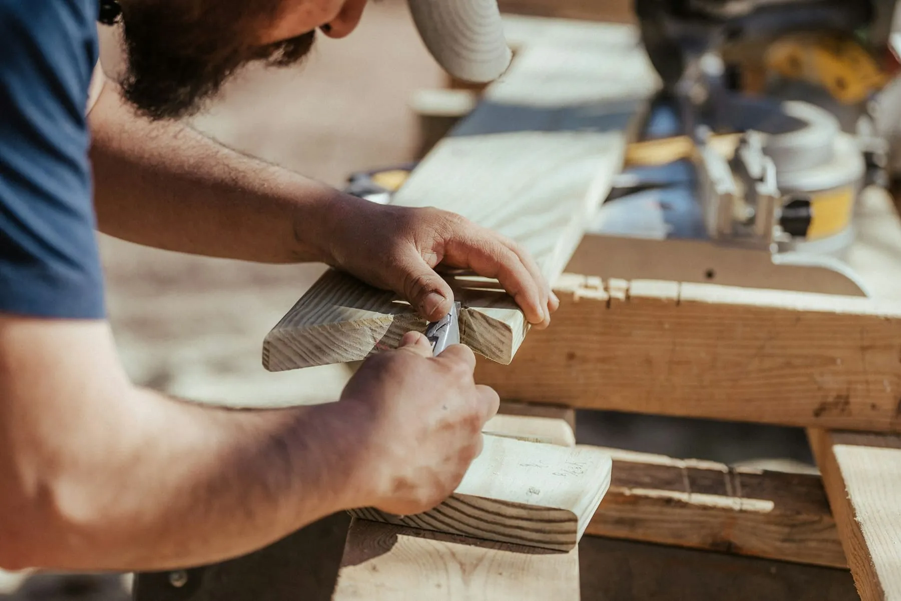 Charpentier ajustant une pièce de bois à la main