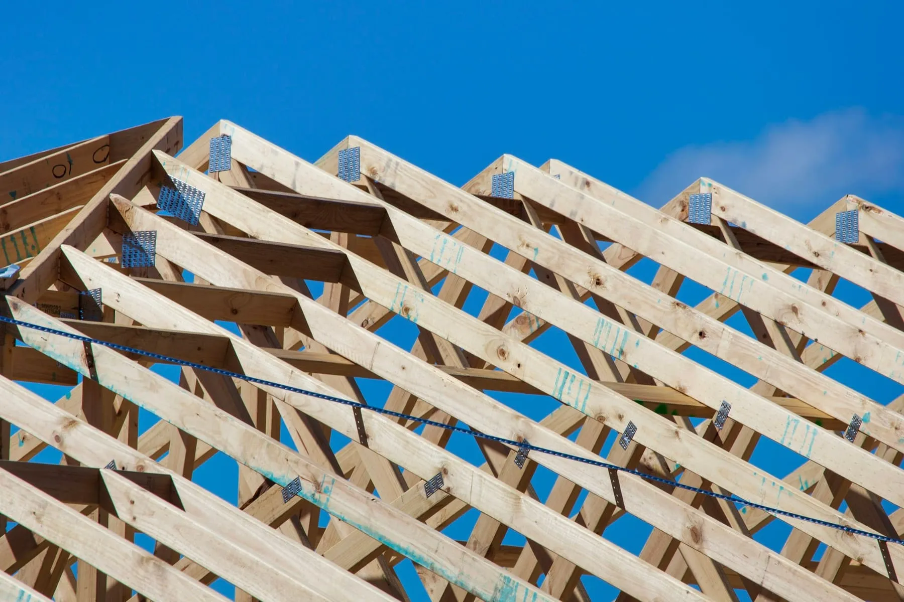 Charpente neuve en bois levée sur une maison, sous un ciel bleu